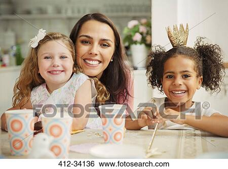 Portrait smiling mother and daughters at birthday party table View Large Photo Image Stock Photograph - Portrait smiling mother and daughters at birthday party table. Fotosearch
