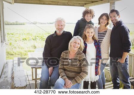 Stock Image - Portrait smiling multi-generation family on porch. Fotosearch