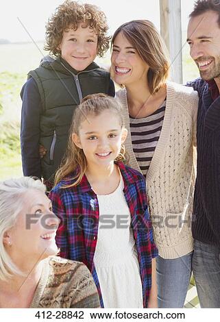 Stock Image - Portrait smiling multi-generation family on porch. Fotosearch