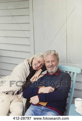 Stock Photo - Portrait smiling senior couple hugging on patio. Fotosearch