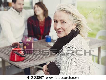 Stock Photo - Portrait smiling senior woman at patio table. Fotosearch