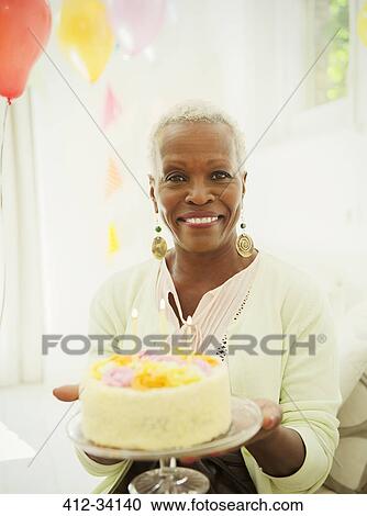 Portrait smiling senior woman holding birthday cake View Large Photo Image Stock Image - Portrait smiling senior woman holding birthday cake. Fotosearch