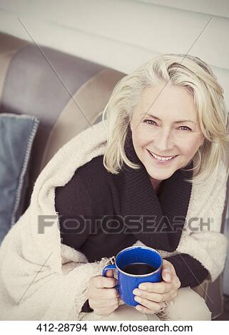 Portrait smiling senior woman wearing shawl drinking coffee on patio View Large Photo Image Picture - Portrait smiling senior woman wearing shawl drinking coffee on patio. Fotosearch