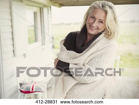 Stock Image - Portrait smiling senior woman wearing shawl on porch. Fotosearch
