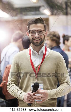 Stock Photo - Portrait smiling speaker with microphone at technology conference. Fotosearch