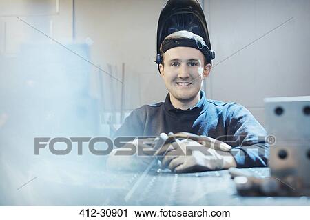 Stock Image - Portrait smiling welder in steel factory. Fotosearch
