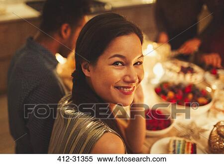Stock Photography - Portrait smiling woman at candlelight dinner party. Fotosearch