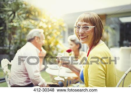 Portrait smiling woman drinking champagne at garden party View Large Photo Image Stock Photo - Portrait smiling woman drinking champagne at garden party. Fotosearch