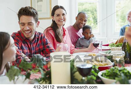 Portrait smiling woman enjoying Christmas dinner with family at table View Large Photo Image Stock Image - Portrait smiling woman enjoying Christmas dinner with family at table. Fotosearch