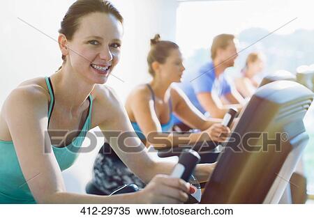 Portrait smiling woman riding exercise bike at gym View Large Photo Image Stock Photography - Portrait smiling woman riding exercise bike at gym. Fotosearch