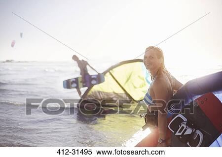 Portrait smiling woman with kiteboard equipment in ocean surf View Large Photo Image Stock Photography - Portrait smiling woman with kiteboard equipment in ocean surf. Fotosearch