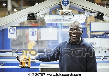 Portrait smiling worker at machine in steel factory View Large Photo Image Stock Photo - Portrait smiling worker at machine in steel factory. Fotosearch