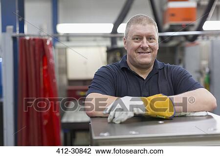 Stock Image - Portrait smiling worker in steel factory. Fotosearch