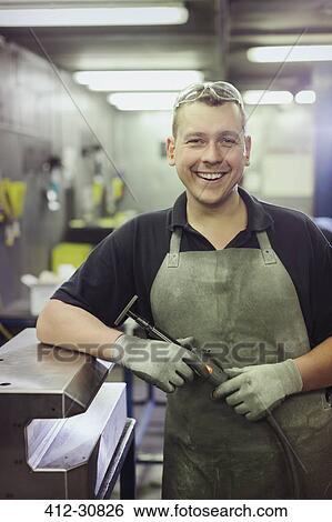 Portrait smiling worker in steel factory View Large Photo Image Stock Photograph - Portrait smiling worker in steel factory. Fotosearch