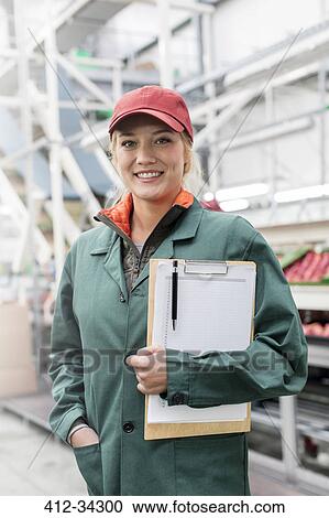 Portrait smiling worker with clipboard in food processing plant View Large Photo Image Stock Image - Portrait smiling worker with clipboard in food processing plant. Fotosearch