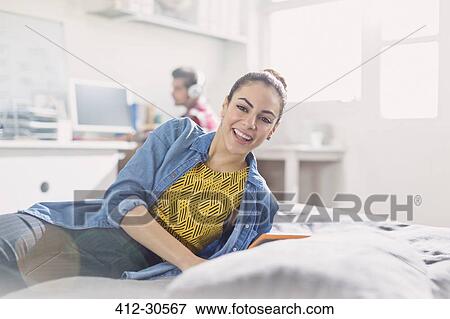 Portrait smiling young adult woman reading on bed View Large Photo Image Stock Photo - Portrait smiling young adult woman reading on bed. Fotosearch