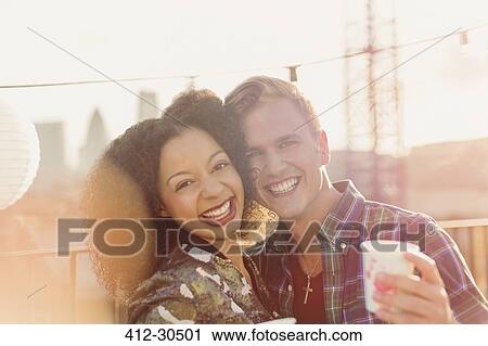 Portrait smiling young couple enjoying rooftop party View Large Photo Image Stock Image - Portrait smiling young couple enjoying rooftop party. Fotosearch