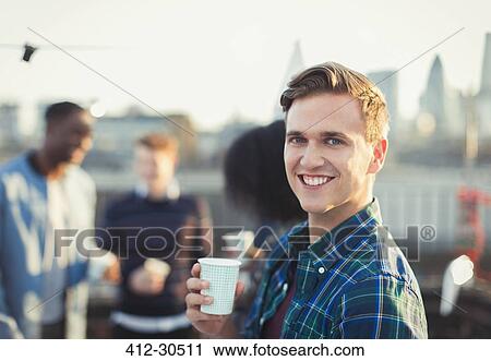 Portrait smiling young man drinking at rooftop party View Large Photo Image Stock Image - Portrait smiling young man drinking at rooftop party. Fotosearch