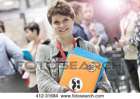 Portrait smiling young woman with laptop at technology conference View Large Photo Image Picture - Portrait smiling young woman with laptop at technology conference. Fotosearch