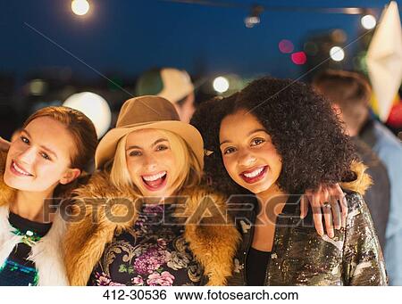 Portrait smiling young women enjoying rooftop party View Large Photo Image Stock Photograph - Portrait smiling young women enjoying rooftop party. Fotosearch