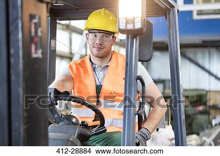 Picture - Portrait worker driving forklift in factory. Fotosearch