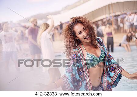 Stock Image - Portrait young woman dancing at poolside party. Fotosearch