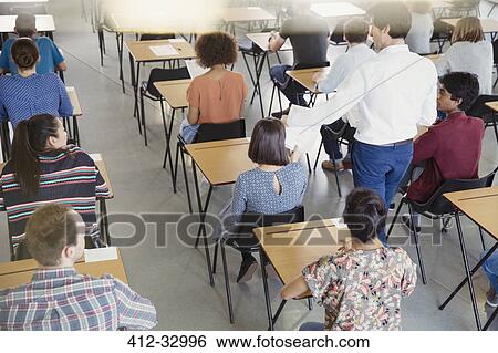 Professor collecting test from students in classroom View Large Photo Image Stock Photograph - Professor collecting test from students in classroom. Fotosearch
