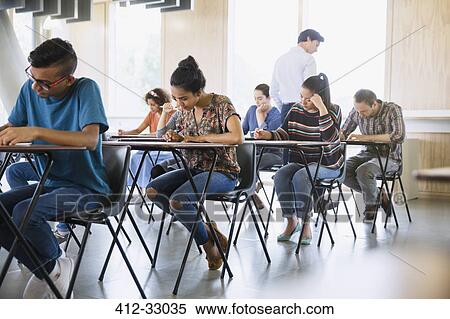 Professor watching college students taking test in classroom View Large Photo Image Stock Photography - Professor watching college students taking test in classroom. Fotosearch