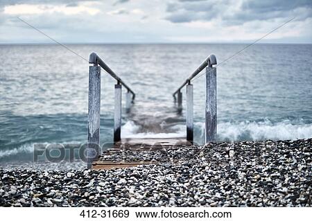 Ramp with railing leading into ocean, Devon, United Kingdom View Large Photo Image Stock Photo - Ramp with railing leading into ocean, Devon, United Kingdom. Fotosearch