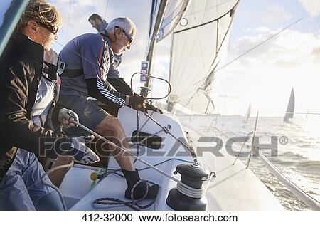 Retired couple sailing pulling rigging on sailboat View Large Photo Image Stock Image - Retired couple sailing pulling rigging on sailboat. Fotosearch