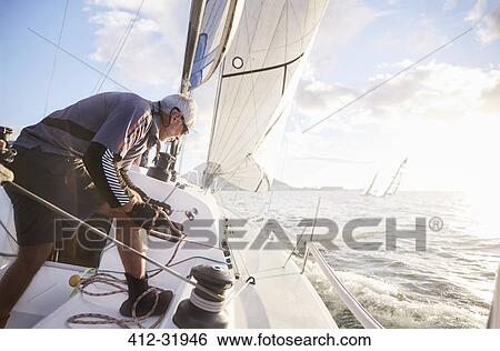 Stock Photograph - Retired man sailing on sunny ocean. Fotosearch