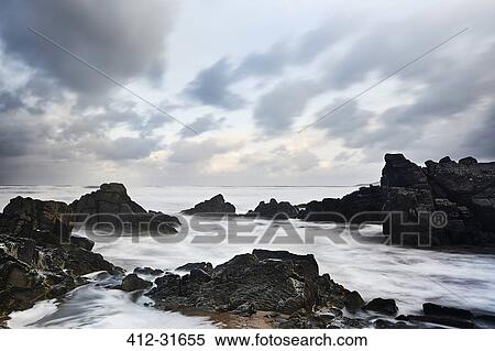 Rocks and ocean under cloudy sky, Devon, United Kingdom View Large Photo Image Stock Photography - Rocks and ocean under cloudy sky, Devon, United Kingdom. Fotosearch