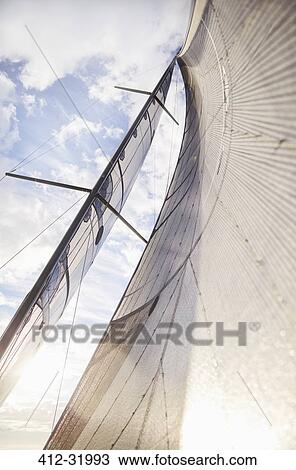 Stock Image - Sailboat sail against sunny sky. Fotosearch
