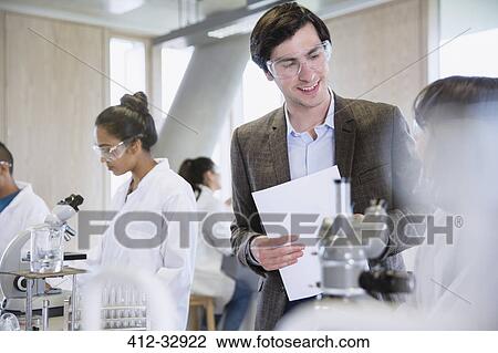 Stock Image - Science professor helping college student in science laboratory classroom. Fotosearch