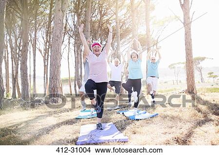 Senior adults practicing yoga in sunny park View Large Photo Image Picture - Senior adults practicing yoga in sunny park. Fotosearch