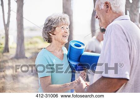 Senior couple holding hands after yoga class in park View Large Photo Image Stock Photograph - Senior couple holding hands after yoga class in park. Fotosearch