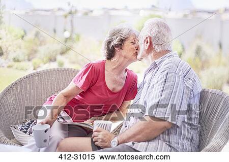 Senior couple kissing and drinking coffee on patio View Large Photo Image Stock Photography - Senior couple kissing and drinking coffee on patio. Fotosearch