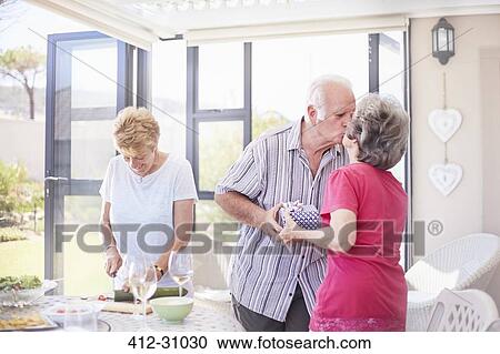 Senior couple kissing at patio lunch View Large Photo Image Stock Image - Senior couple kissing at patio lunch. Fotosearch