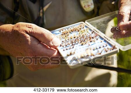 Senior man holding fishing reel hooks View Large Photo Image Stock Photo - Senior man holding fishing reel hooks. Fotosearch