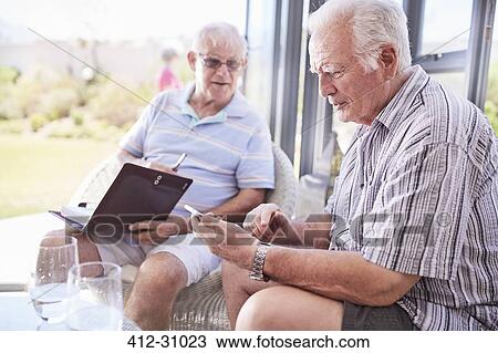 Senior men texting with cell phone on patio View Large Photo Image Stock Image - Senior men texting with cell phone on patio. Fotosearch