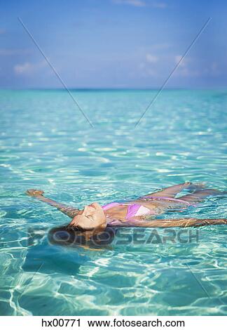 Serene woman floating in tropical ocean View Large Photo Image Stock Image - Serene woman floating in tropical ocean. Fotosearch