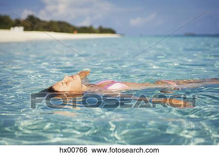 Serene woman floating in tropical ocean View Large Photo Image Stock Photograph - Serene woman floating in tropical ocean. Fotosearch