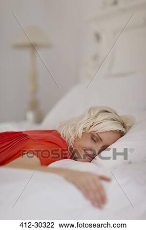 Serene woman sleeping on bed View Large Photo Image Stock Image - Serene woman sleeping on bed. Fotosearch
