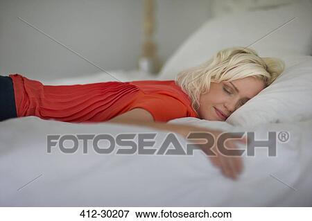 Serene woman sleeping on bed with eyes closed View Large Photo Image Stock Photo - Serene woman sleeping on bed with eyes closed. Fotosearch