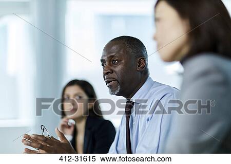 Stock Photography - Serious businessman talking in meeting. Fotosearch