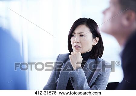 Serious businesswoman listening in meeting View Large Photo Image Stock Photograph - Serious businesswoman listening in meeting. Fotosearch