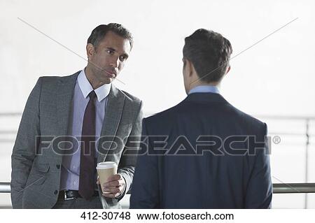 Serious corporate businessmen drinking coffee and talking View Large Photo Image Stock Photo - Serious corporate businessmen drinking coffee and talking. Fotosearch