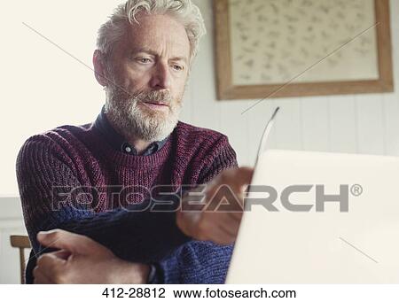 Stock Image - Serious man using laptop. Fotosearch