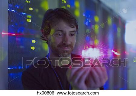 Server room technician holding illuminated computer chip View Large Photo Image Stock Photograph - Server room technician holding illuminated computer chip. Fotosearch