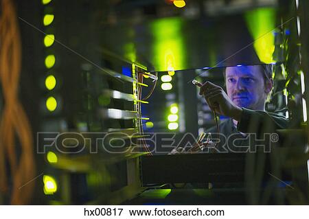 Stock Photo - Server room technician with cable at panel. Fotosearch
